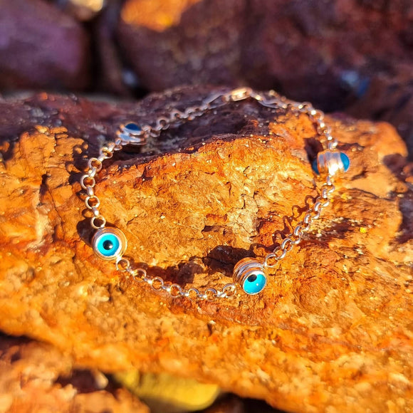 Our Bondi Evil Eye bracelet is a statement piece with a beautiful story. Deriving from Mediterranean origin, the Evil Eye is a superstitious curse, believed to be cast by a malevolent glare, usually given to a person who is unaware. Jewellery with the eye symbol were created to give the wearer protection against the evil eye. (Sourced from wikipedia)  Featuring four evil eye attachments each connected by a delicate rolo chain and lobster clasp.  Material:  18K Gold Vermeil with a Sterling Silver base