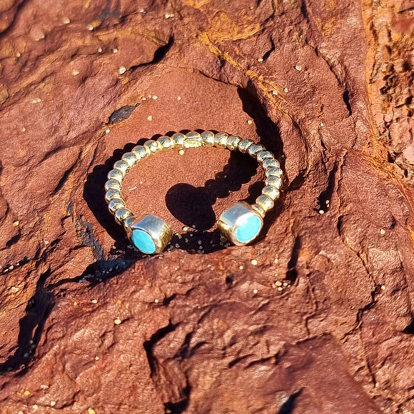 Our Beaded Turquoise Ring features a delicate and adjustable gold beaded band topped off by two turquoise stones. We love featuring this beautiful stone in our jewellery as turquoise as a colour embodies stability, open-mindedness, and relaxation.  We recommend pairing this piece with two or more of our other Salaqua rings for the best look and feel.    Material:  18K Gold Vermeil with a Sterling Silver base